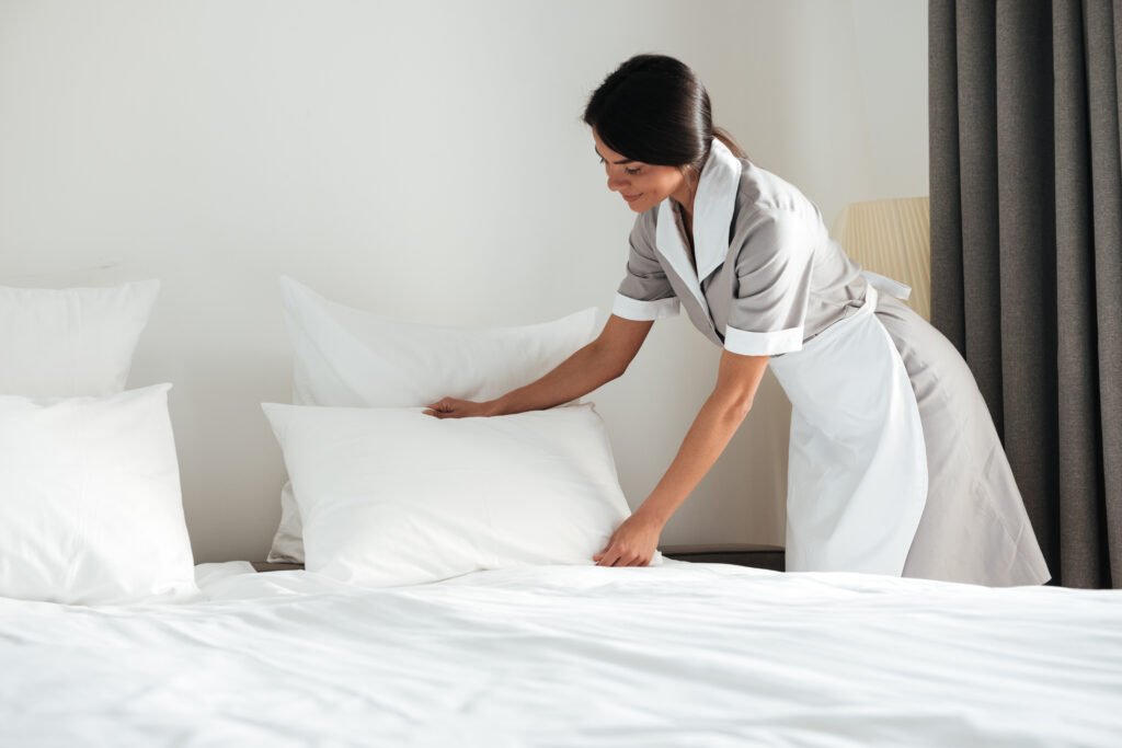 Service de ménage professionnel avec Homely pour vos locations Airbnb Employée Homely préparant une chambre pour une location Airbnb avec un service de ménage professionnel